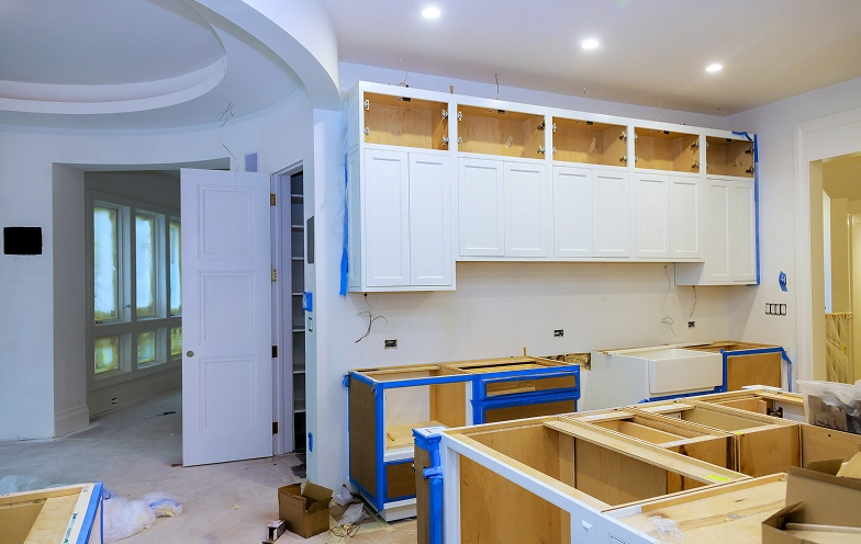 Kitchen under renovation with open cabinets.